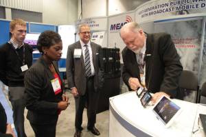 FCC Commissioner Mignon Clyburn discusses the latest M-EAS applications with Steve Heinz at NAB 2014 as John Lawson looks on.